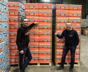 فرانکلین گینوس (راست) و شریکش رندی ون دینتر در مقابل جعبه های BeFrank آبی-نارنجی خود ایستاده اند که حاوی اولین موز 100٪ قیمت واقعی در جهان است.